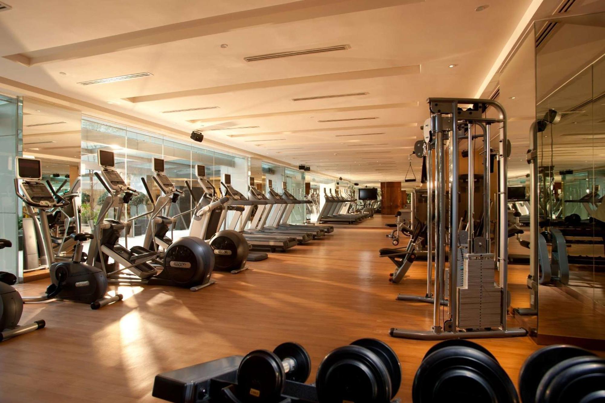 Готель Doubletree By Hilton Куала-Лумпур Екстер'єр фото The photo shows a modern gym interior. It features various fitness equipment including treadmills, exercise bikes, and weight machines. The gym has a spacious layout with large windows that allow natural light to enter, creating a bright and inviting